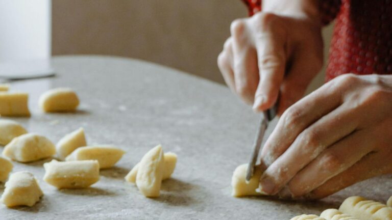 Mani di madre e figlia che impastano gnocchi del 29 su un tavolo di farina, simbolo di tradizione e memoria familiare tra Argentina, Texas e Ciociaria